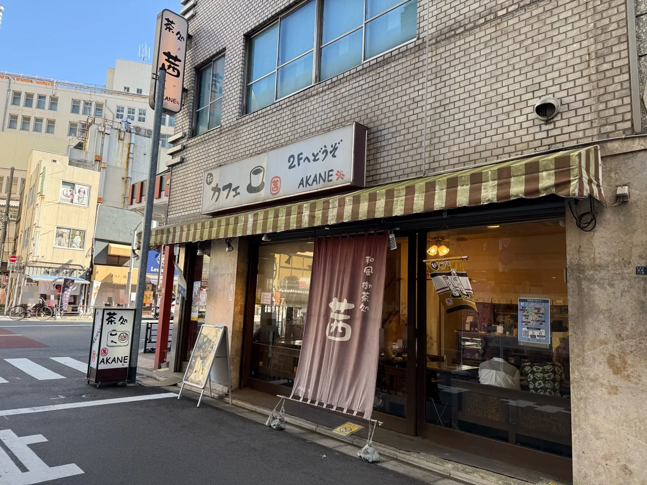 茶処茜の縞模様のひさしと店頭の暖簾