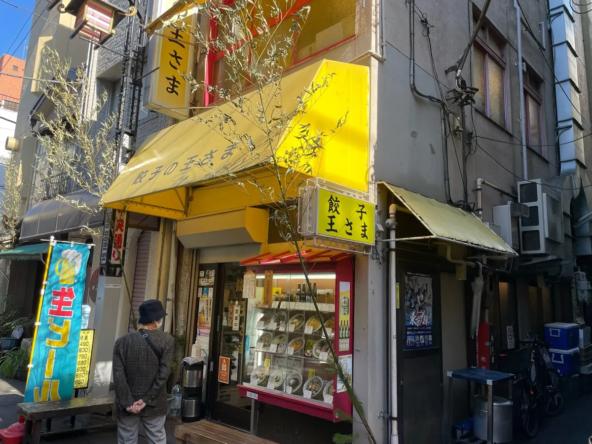 浅草の餃子の王さまの黄色い看板、ひさし、入口の食品サンプル