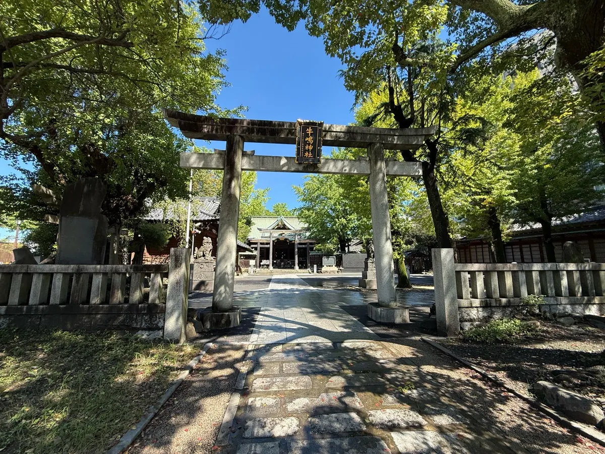 牛嶋神社の社名額が掲げられた石鳥居と奥に見える社殿